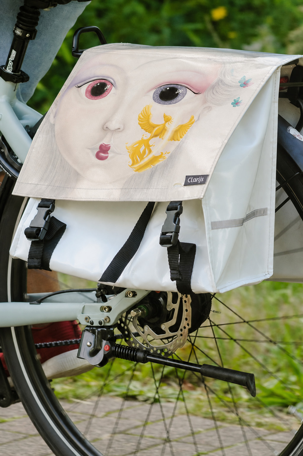 Bicycle pannier with the artwork Rising Phoenix mounted on a bicycle